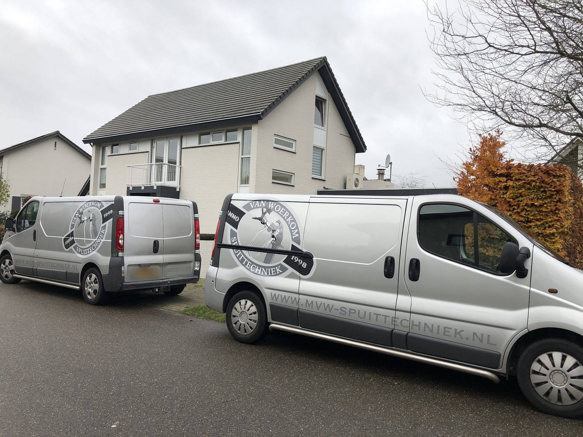De twee bedrijfsbussen van Van Woerkom Spuittechniek met het logo op de zijkant