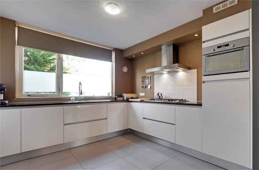 Keuken met witte kasten en taupe wanden