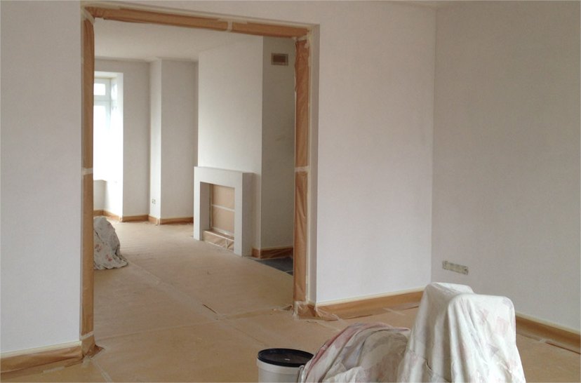 Afgeplakte deuropening met afgedekte vloer tijdens het werk