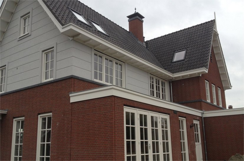 Groot woonhuis met een witte bovengevel en witte kozijnen boven rode baksteen
