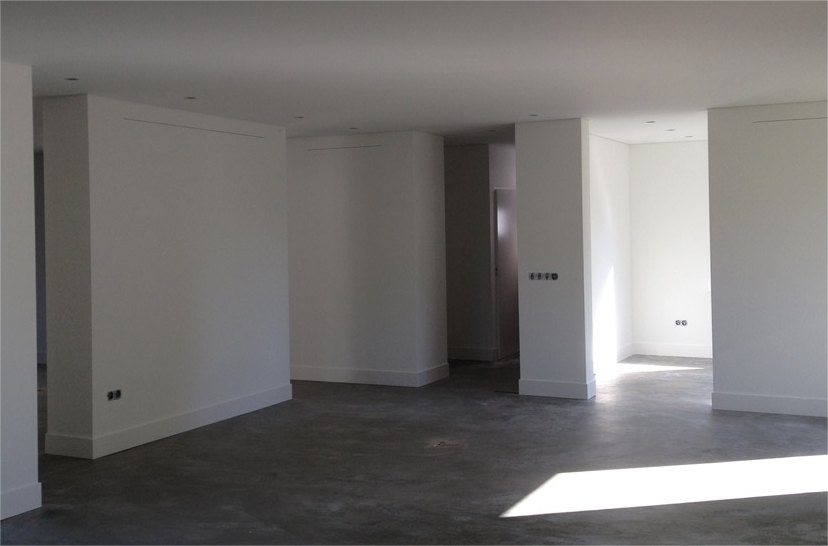 Lege, lichte ruimte met witte wanden en een betonvloer